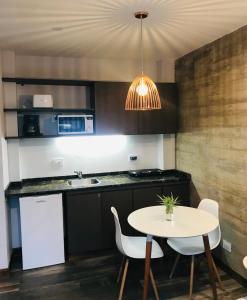 a kitchen with a table and chairs and a sink at Excelente Apartamento, a metros del Parque San Martín! in Mendoza