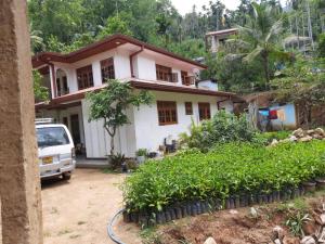 a house with a van parked in front of it at Family Holiday Inn in Badulla