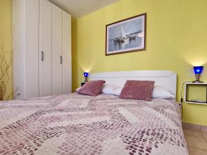 una camera da letto con un grande letto con cuscini viola di Apartment Devcic a Šilo