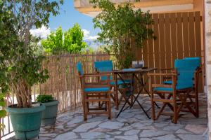 a table and chairs on a patio with trees at Maria's House in Nydri