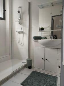 a white bathroom with a shower and a sink at Joli studio les pieds dans l eau avec place de Parking gratuite in Bandol