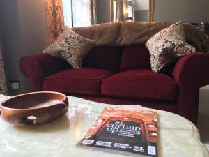un libro y un tazón en una mesa frente a un sofá en The Cheese Room, self-contained cosy retreat in the Quantock Hills en Bridgwater