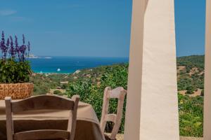 a table and chairs with a view of the ocean at Borgo Alba Barona Turismo Rurale in Golfo Aranci