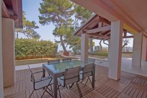 a glass table and chairs on a patio at Jelena B4 in Veli Lošinj