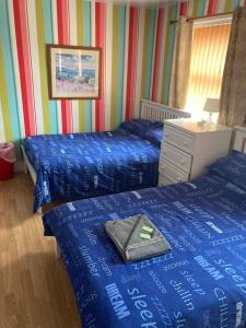 Un dormitorio con dos camas y un tocador con una bolsa. en Fairhaven Hotel on Woodfield Road, en Blackpool