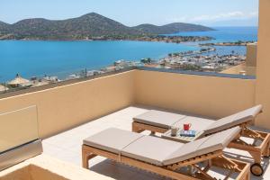 a hotel room with a balcony overlooking the ocean at Elounda Heights (Adults Only) in Elounda