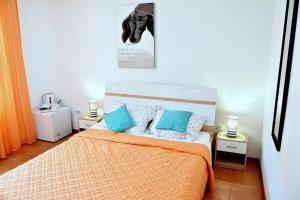 a bedroom with a bed with blue pillows at Rooms Vilma close to Rab City in Rab