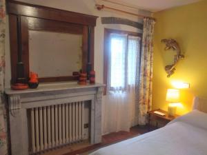 ArcugnanoにあるCa' del Vento B&Bのベッドルーム(暖炉、ベッド、鏡付)