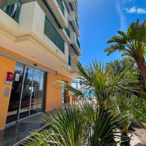 a building with palm trees in front of it at Princess Et Richmond in Menton