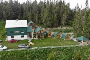 una vista aérea de una casa con coches estacionados en un campo en Razvršje Co en Žabljak