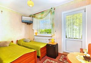 twee bedden in een kamer met een raam en een televisie bij Pokoje Gościnne Konkel in Władysławowo