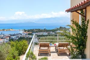 a balcony with chairs and a view of the ocean at Elounda Heights (Adults Only) in Elounda