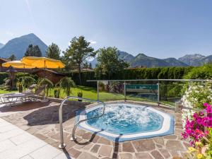 una vasca idromassaggio su un patio con montagne sullo sfondo di Hotel Karlwirt a Pertisau