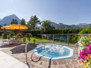 a hot tub on a patio with mountains in the background at Hotel Karlwirt in Pertisau