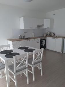 una cucina con tavolo bianco e sedie bianche di Apartmán Pri Jazere - Slnečné jazerá JUH a Senec