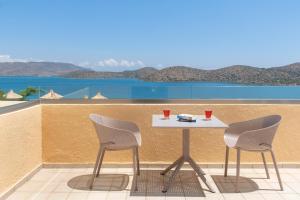 a table and two chairs on a balcony with a view at Elounda Heights (Adults Only) in Elounda