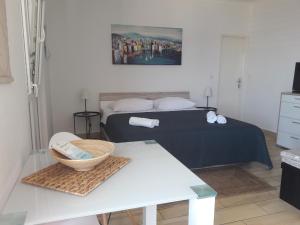 een slaapkamer met een bed en een tafel met een mand bij Apartment Tea in Primošten