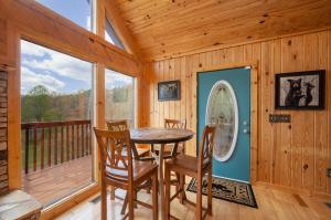 a dining room with a table and chairs on a deck at BareFoot Cabin cabin in Sevierville +24 photos