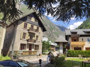 a building in a village with a mountain in the background at Maison De La Muzelle, Venosc - Les Deux Alpes in Vénosc