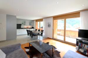 a kitchen and living room with a table and chairs at Aramis in Saas-Fee