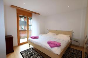サースフェーにあるAramisのベッドルーム1室(紫色のタオルが付いたベッド1台付)