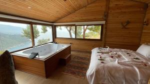 a large room with a tub and a bed in it at Olive Garden Kabak in Faralya