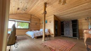 a bedroom with a bed in a wooden cabin at Olive Garden Kabak in Faralya