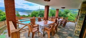 a patio with tables and chairs on a balcony with a view at Villa Eskici in Staro Myasto