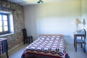 1 dormitorio con cama, mesa y ventana en Mas provençal isolé en pleine nature, en Montjoyer