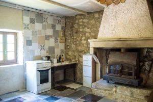 cocina con fogones y chimenea de piedra en Mas provençal isolé en pleine nature, en Montjoyer