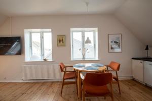 a dining room with a table and chairs and two windows at Lake Views in Gråsten