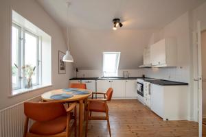 - une cuisine avec une table et des chaises dans la chambre dans l'établissement Lake Views, à Gråsten