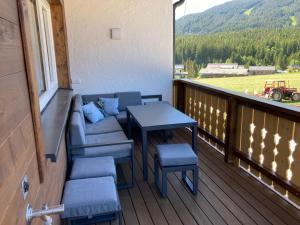 a balcony with a table and chairs and a view at Deluxe Appartement Blasbichlerhof in Ramsau am Dachstein