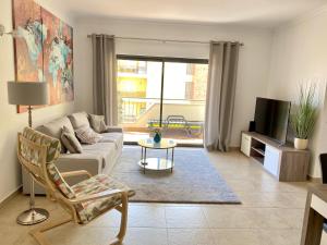 a living room with a couch and a tv at George's Quinta das Palmeiras, a 2 bedroom apartment in luxury complex, walking distance to town in Lagos