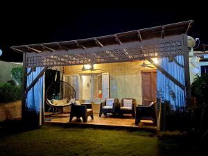 a patio at night with chairs and a swing at Chalet with backyard in North Coast near Marina & New Alamein الساحل الشمالي العلمين in El Alamein