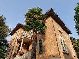 a palm tree in front of a building at Villa Berghinz in Venice-Lido