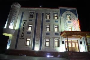 ein großes weißes Gebäude mit Lichtern in der Nacht in der Unterkunft Sultan Hotel Boutique in Samarkand