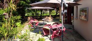 un groupe de chaises et de tables avec un parasol dans l'établissement Hostellerie du Parc, à Labarthe-Inard