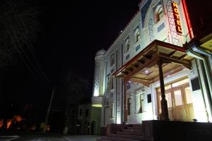un edificio con un cartel en la parte delantera de la noche en Sultan Hotel Boutique, en Samarkand