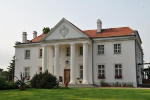 una gran casa blanca con techo rojo en Restauracja - Hotel Pałacowa, en Rogowo