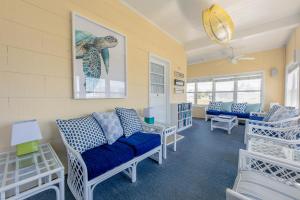 ein Wohnzimmer mit einem blauen Sofa und Stühlen in der Unterkunft Windward at the Beach in Beach Haven
