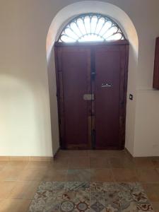 a wooden door in a room with a window at Casa Cristina in Alì Terme