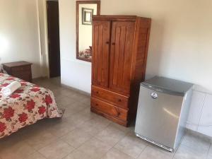 ein Schlafzimmer mit einer Kommode und einem kleinen Kühlschrank in der Unterkunft Cabaña La Martina in Chilecito