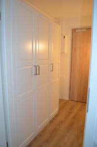 Pokój z białymi drzwiami od szafy i drewnianą podłogą w obiekcie Glück am Meer w mieście Glücksburg