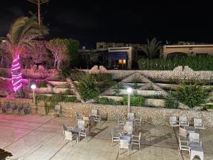 a patio with chairs and lights at night at Chalet with backyard in North Coast near Marina & New Alamein الساحل الشمالي العلمين in El Alamein