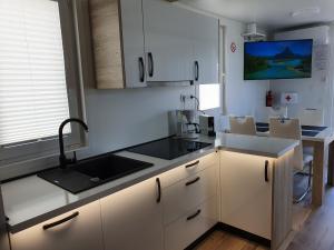 a kitchen with white cabinets and a sink at Floating House SENA in Pula