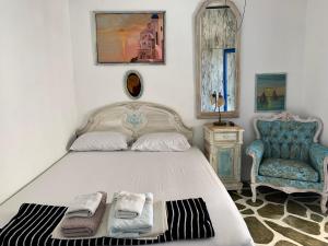 a bedroom with a large bed with a chair and towels at Summer House in Porto Heli