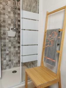 a bathroom with a shower and a towel on a chair at Houses of Eira Velha in Fajã do Ouvidor