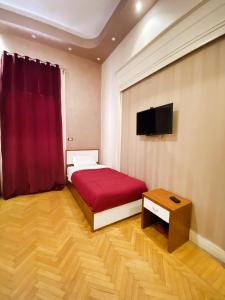 1 dormitorio con cama roja y TV en Nour Hostel, en El Cairo