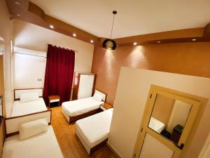a small room with two beds and a mirror at Nour Hostel in Cairo